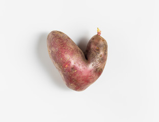 Trendy ugly food concept. Funny potatoes in the shape of a heart on a white background. Vegetable...
