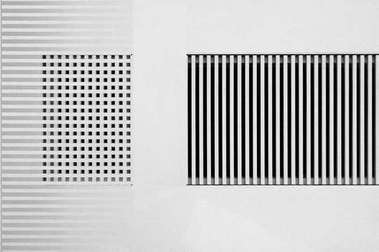 Lath structures of slots and cells. Stripes and checkers pattern in shades of gray. Interior design of architecture background against white stucco wall. Abstract geometric template.
