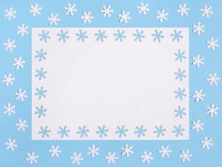 Christmas mockup with snowflakes on pastel blue background. Space for text. Greeting card. Winter concept.