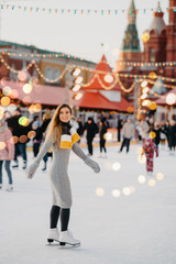 Beautiful woman is enjoy to be at ice-skate on the Red Square rink, Moscow, Russia