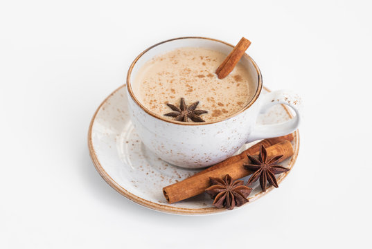 Indian Masala chai tea. Traditional Indian hot drink with milk and spices on white background closeup.