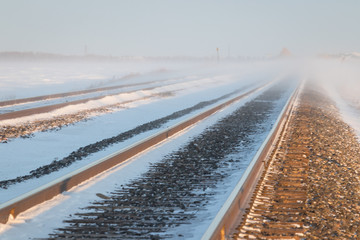 Blowing Snow over a Pair of Railway Tracks in the Desolate Prairie