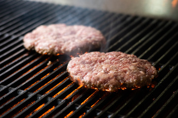 cooking burgers on hot grill with flames