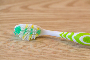 Used toothbrush on wooden background