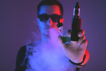 Vaping man with vaporizer and a cloud of vapor