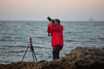 professional photographer takes pictures on the background of the sea