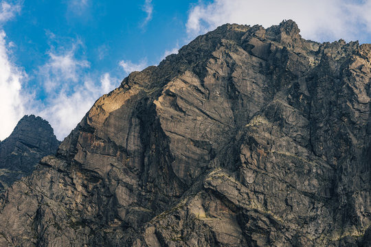Detail of a mountain rock face, background or wallpaper picture of big wall rock climb, clouds and mist, stone and rock surface. Huge rock wall of granite in High Tatras, Slovakia.
