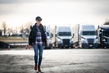 Woman commercial truck driver walking in trucking yard