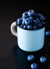 A tasty and healthy snack: juicy and sweet blueberries on black background