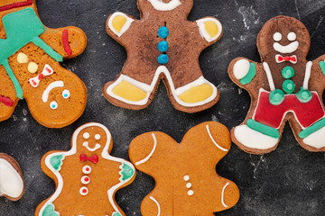 Various christmas gingerbread man cookies on dark table