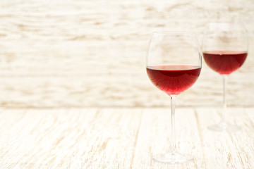 two glasses of red wine on a white wooden background, with copy space.