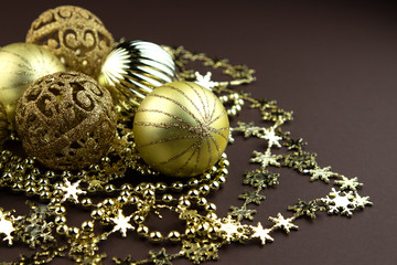 Golden sparkly Christmas balls on brown background. Magic holiday card. Christmas or New Year festive composition.