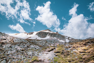 Landscape view of a snow-capped mountain. The path leading to the highest peak Golem Korab. SpringTime in Mavrovo national park, North Macedonia.