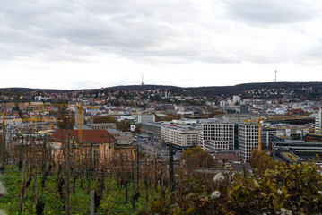 Germany, Houses of city stuttgart in valley surrounded by many hills and mountains forested with...