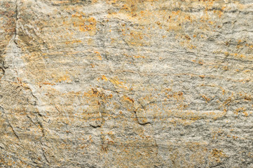 Texture of gray stone with a natural pattern and yellow splashes. Universal background.
