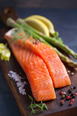 Fresh raw salmon fillet steak with vegetables and ingredients prepared for cooking