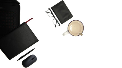 Isolated desktop top view. Working space. Office table. Notebook, a load of hot cappuccino, glasses, pen, notebook. On white background. Minimalism, close-up of the workplace.