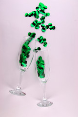 It`s party time! Isolated two champagne glasses with glittering green ornaments on a white background.