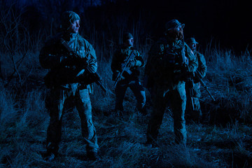 Army soldiers crew patrolling territory at night