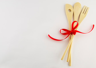 Kitchen accessories on a white background with red decorative ribbon.