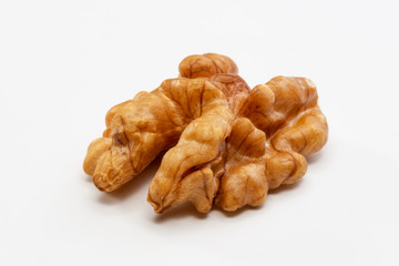 One peeled walnut on a white background.