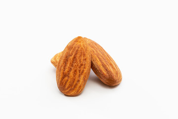 Close up shot of three roasted almonds on a white background.