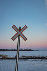 Traditional Railroad Crossing Sign at Sunset in Winter Vertical Crop