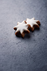 Obraz na płótnie Canvas Christmas cookies (cinnamon stars) on dark stone background. Close up. Copy space.