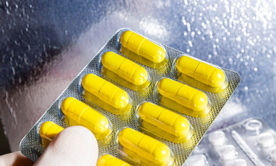 concept of drug treatment and pharmaceuticals, yellow antibiotic pills in a blister pack.
