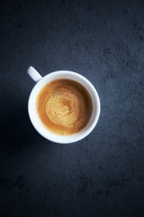 Cup of coffee on dark stone background. Top view. Copy space