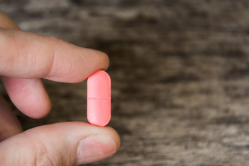 Pink pills in hand close-up