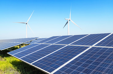 Solar panels and wind turbines generating electricity is solar energy and wind energy in hybrid power plant systems station use renewable energy to generate electricity with blue sky 