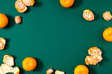 Christmas minimal fruit composition. Frame made of tangerines on dark green background. Christmas, New Year, winter concept. Merry christmas background. Flat lay, top view, copy space