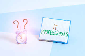 Conceptual hand writing showing It Professionals. Concept meaning any demonstrating associatedand expert with the computer world Alarm clock beside a Paper sheet placed on pastel backdrop