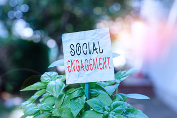 Word writing text Social Engagement. Business photo showcasing one s is degree of participation in a community or society Plain empty paper attached to a stick and placed in the green leafy plants