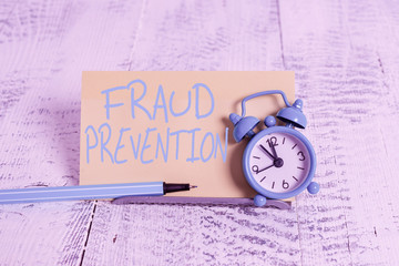 Handwriting text Fraud Prevention. Conceptual photo the act of stopping various types of internet fraud Mini blue alarm clock stand tilted above buffer wire in front of notepaper