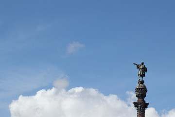 Fototapeta na wymiar Estatua de Colón y cielo de verano