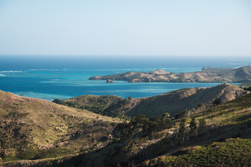 Obraz premium Aerial view on the green mountain tops and small village with ocean in background on Yasawa island group in Fiji, South Pacific
