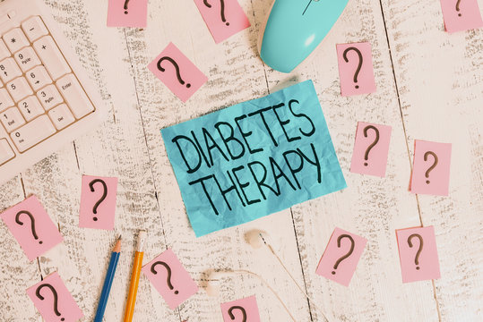 Handwriting text writing Diabetes Therapy. Conceptual photo aim to achieve lower average blood glucose results Writing tools, computer stuff and scribbled paper on top of wooden table