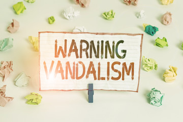 Fototapeta na wymiar Handwriting text writing Warning Vandalism. Conceptual photo malicious defacement of public or private property Colored crumpled papers empty reminder white floor background clothespin