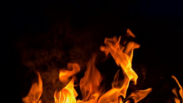 Slow motion fire flame, super slow hot power of bon fire on dark night background, red orange flame glowing and blazing 