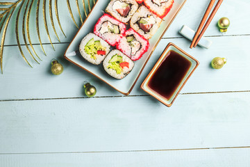 Homemade Christmas sushi set on wooden background and Christmas decorations. Top view. Flat lay