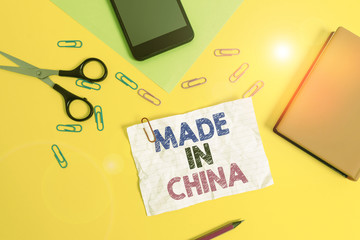 Text sign showing Made In China. Business photo text Wholesale Industry Marketplace Global Trade Asian Commerce Paper sheets pencil clips smartphone scissors notebook colored background