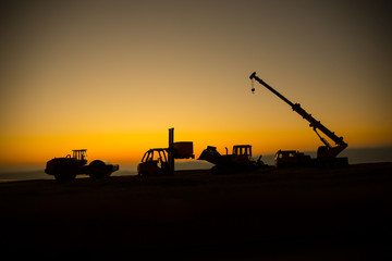 Abstract Industrial background with construction crane silhouette over amazing sunset sky. Mobile...