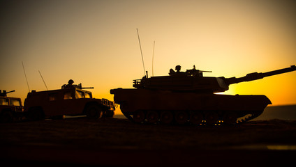 Military patrol car on sunset background. Army war concept. Silhouette of armored vehicle with soldiers ready to attack. Artwork decoration. Selective focus