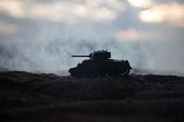 Fototapeta premium War Concept. Military silhouettes fighting scene on war fog sky background, World War German Tanks Silhouettes Below Cloudy Skyline At night. Attack scene.