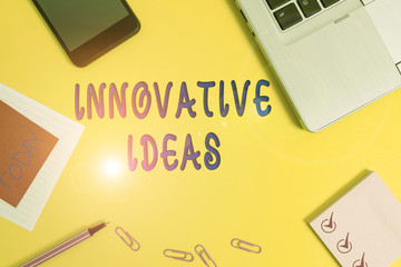 Text sign showing Innovative Ideas. Business photo text application of better solutions that meet new requirements Laptop smartphone notepad marker paper sheet note clips colored background