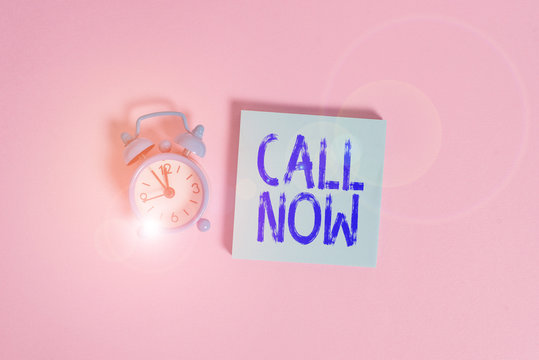 Writing note showing Call Now. Business concept for To immediately contact a demonstrating using telecom devices with accuracy Vintage alarm clock wakeup blank notepad sticky note colored background