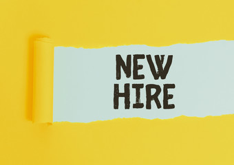 Writing note showing New Hire. Business concept for someone who has not previously been employed by the organization Cardboard which is torn placed above a wooden classic table