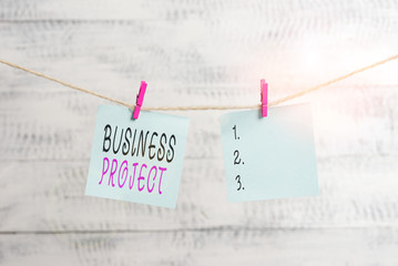 Text sign showing Business Project. Business photo showcasing Planned set of interrelated tasks to be executed over time Clothesline clothespin rectangle shaped paper reminder white wood desk